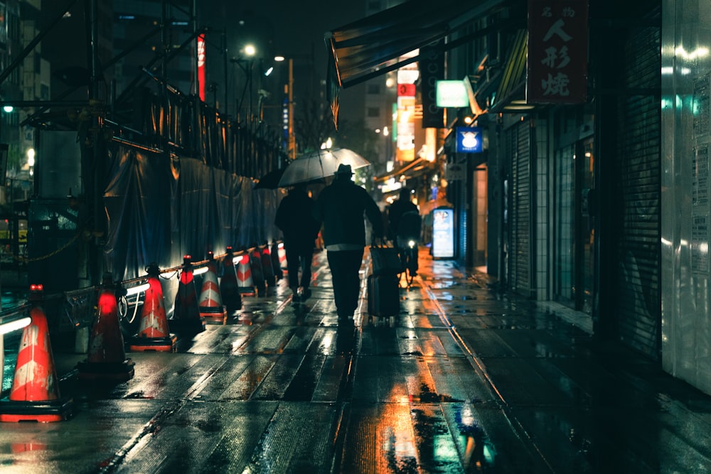 Ein Mann, der eine Straße entlanggeht und einen Regenschirm hält