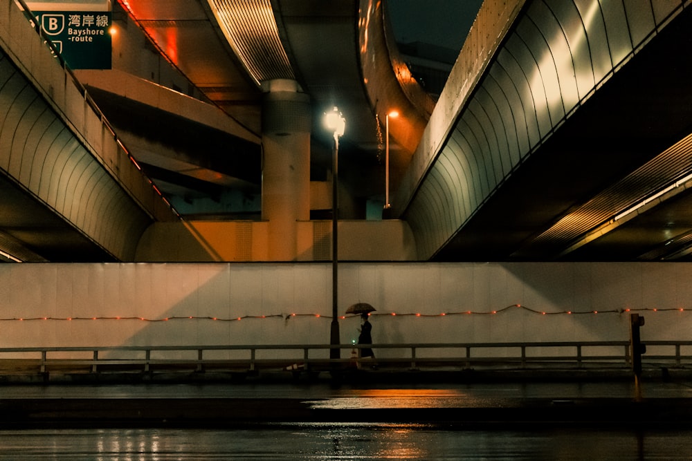 eine Person, die auf einer Brücke über ein Gewässer geht