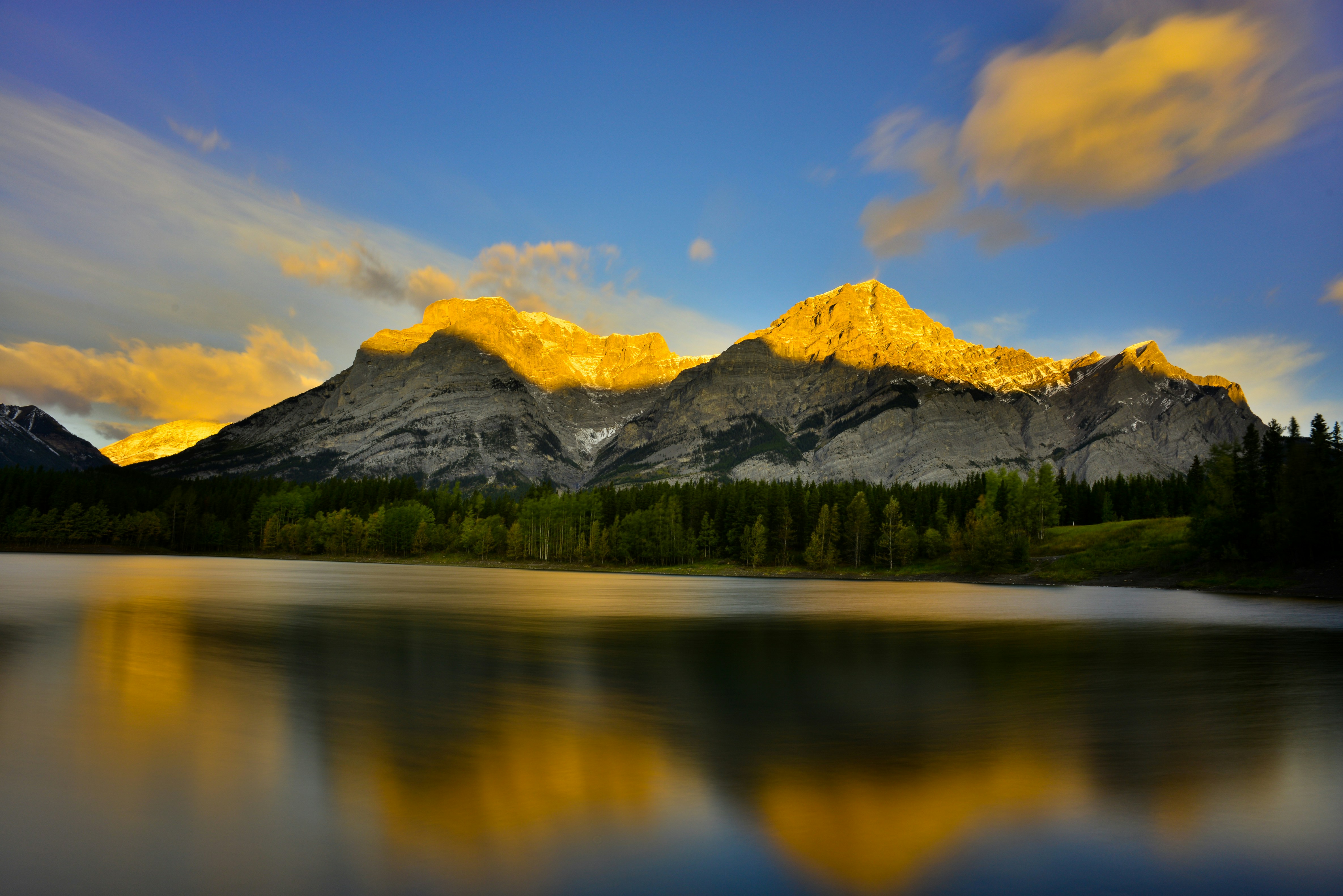a mountain range is reflected in a lake, Sunrise at Wedge Ponds Kananaskis Alberta Canada