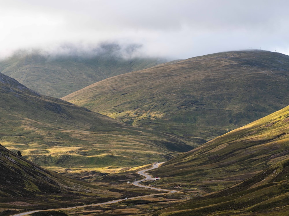 a scenic view of a winding road in the mountains