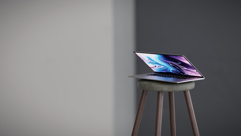 a laptop sitting on a stool in a room