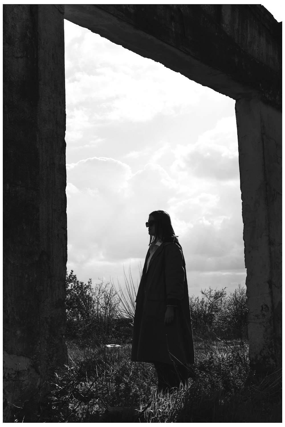 a black and white photo of a man in a trench coat