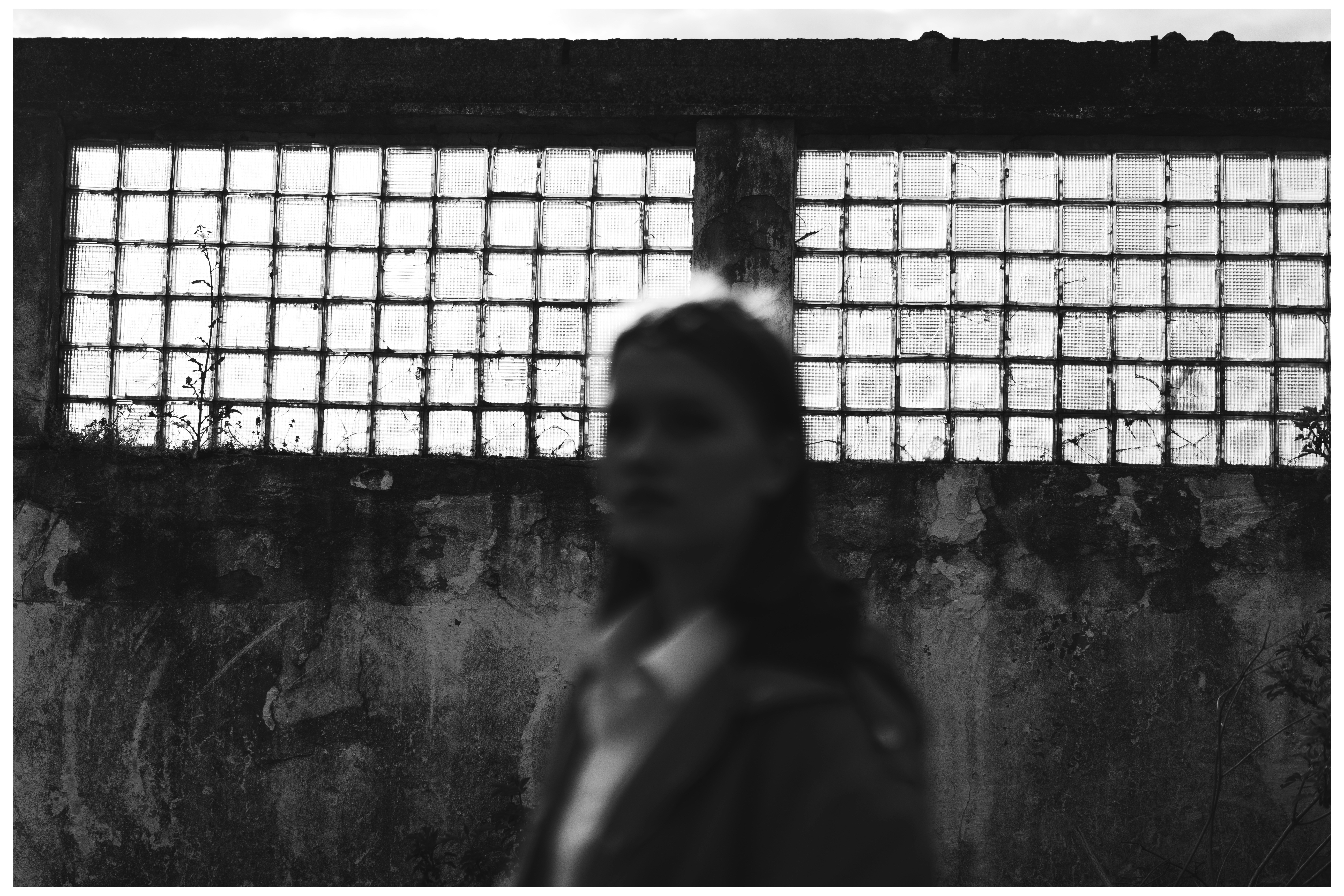 a woman standing in front of a wall with bars on it