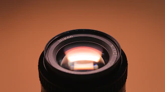 Close-up of a camera lens reflecting warm gold light, symbolizing premium cinematic production.