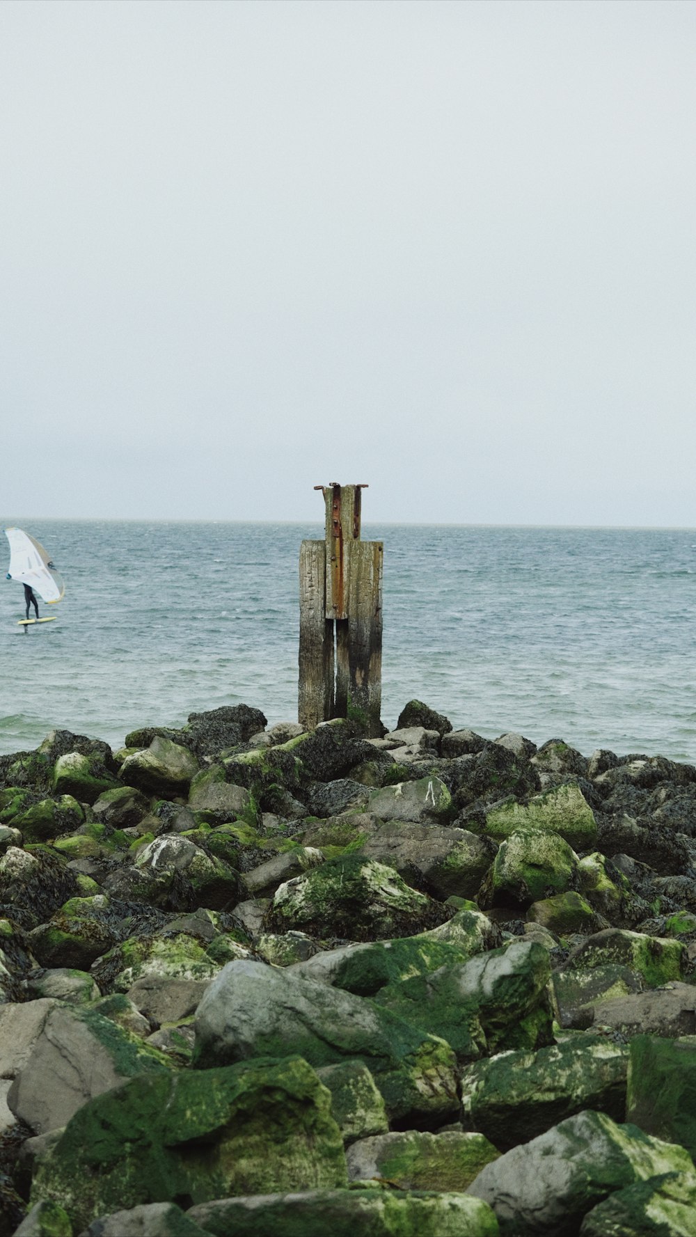 a couple of wooden posts sitting on top of a rocky beach