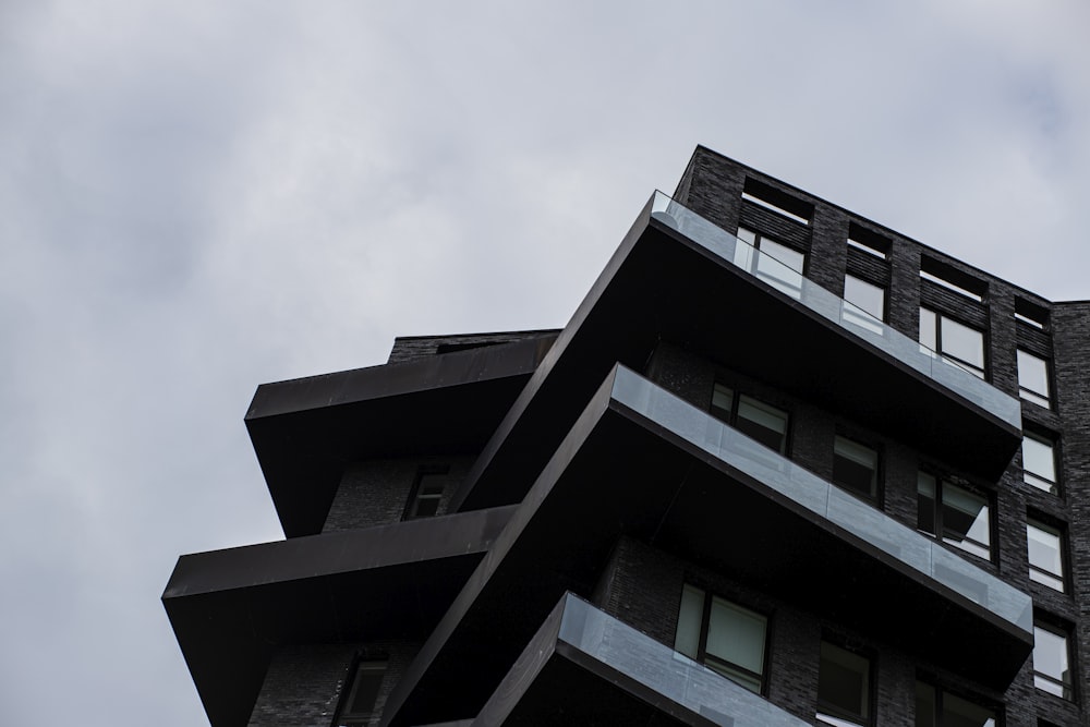 a tall black building with balconies and windows