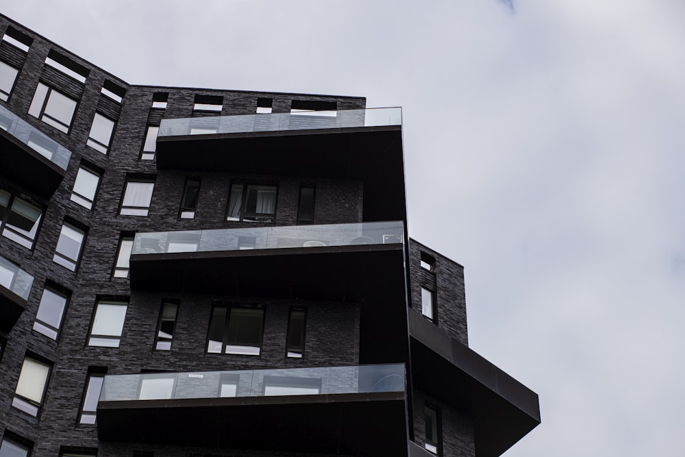 um edifício preto alto com varandas e janelas