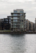 Modern sea-view apartment balcony overlooking calm waterfront.