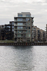 Modern sea-view apartment balcony overlooking calm waterfront.