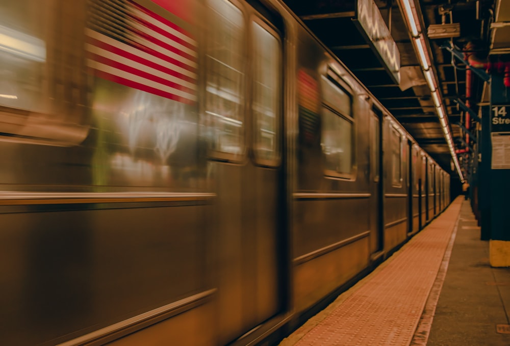 a train speeding past a platform with an american flag on it