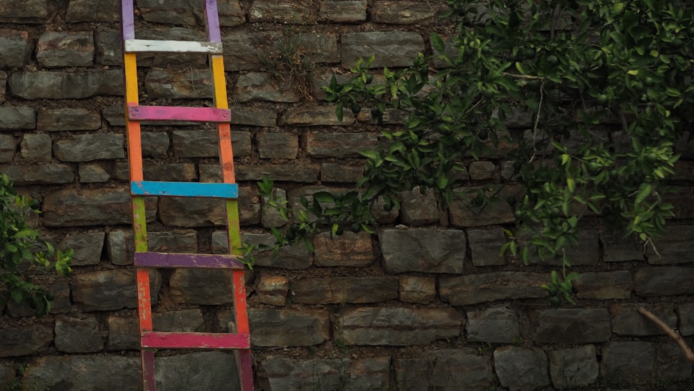 a colorful ladder leaning against a brick wall