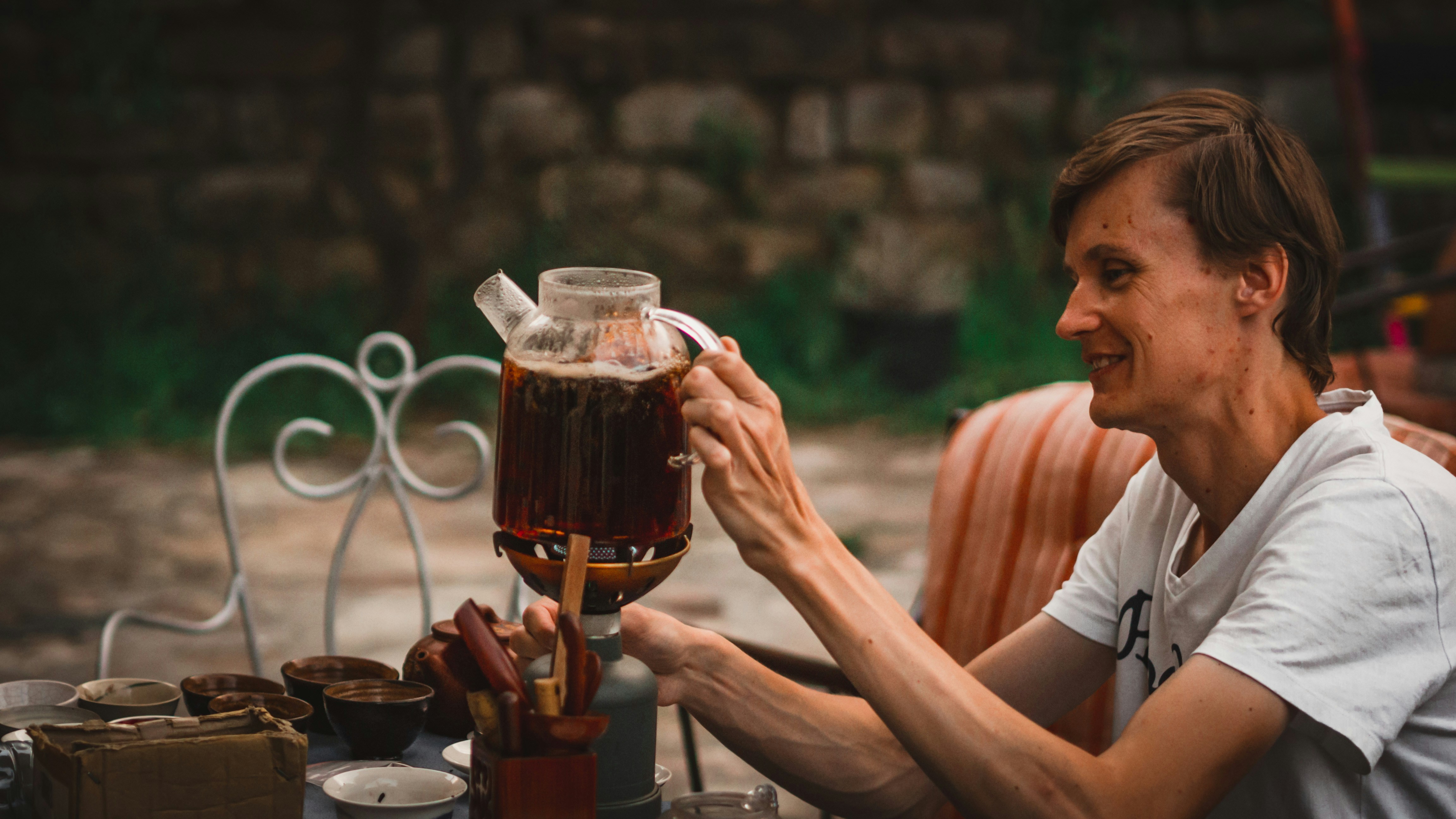 a woman sitting at a table with a pitcher of liquid