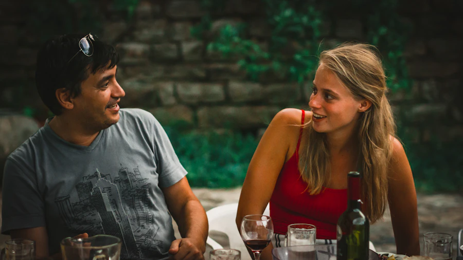Couple échangeant à table devant des verres de vin