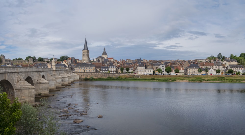 a bridge over a river with a city in the background