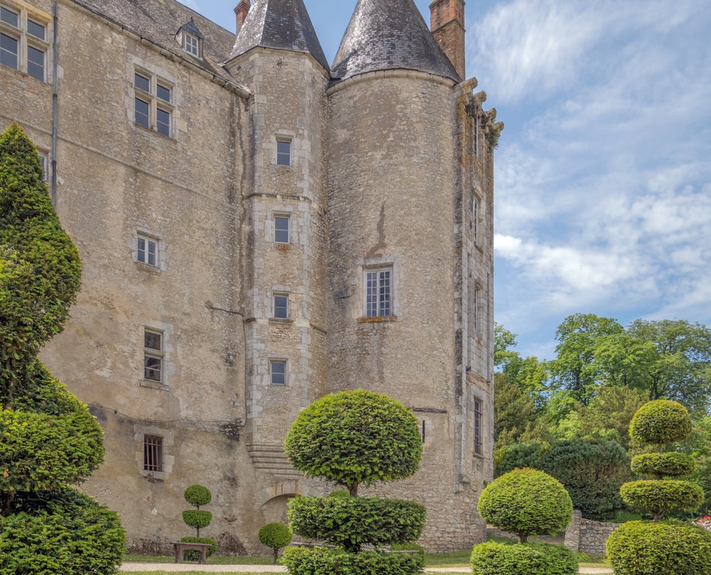 Un grand bâtiment avec beaucoup d’arbres devant lui