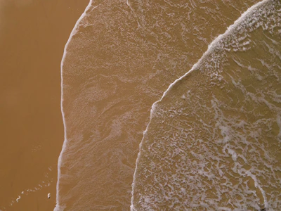 A tranquil shoreline with soft waves creating delicate patterns on the wet sand.