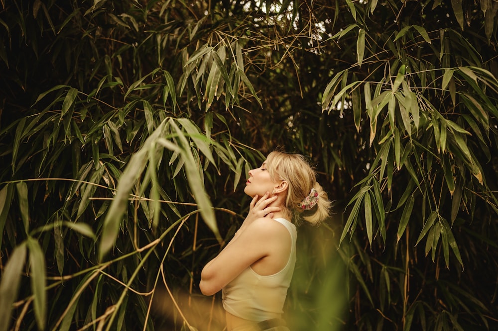 a woman standing in front of a bamboo tree