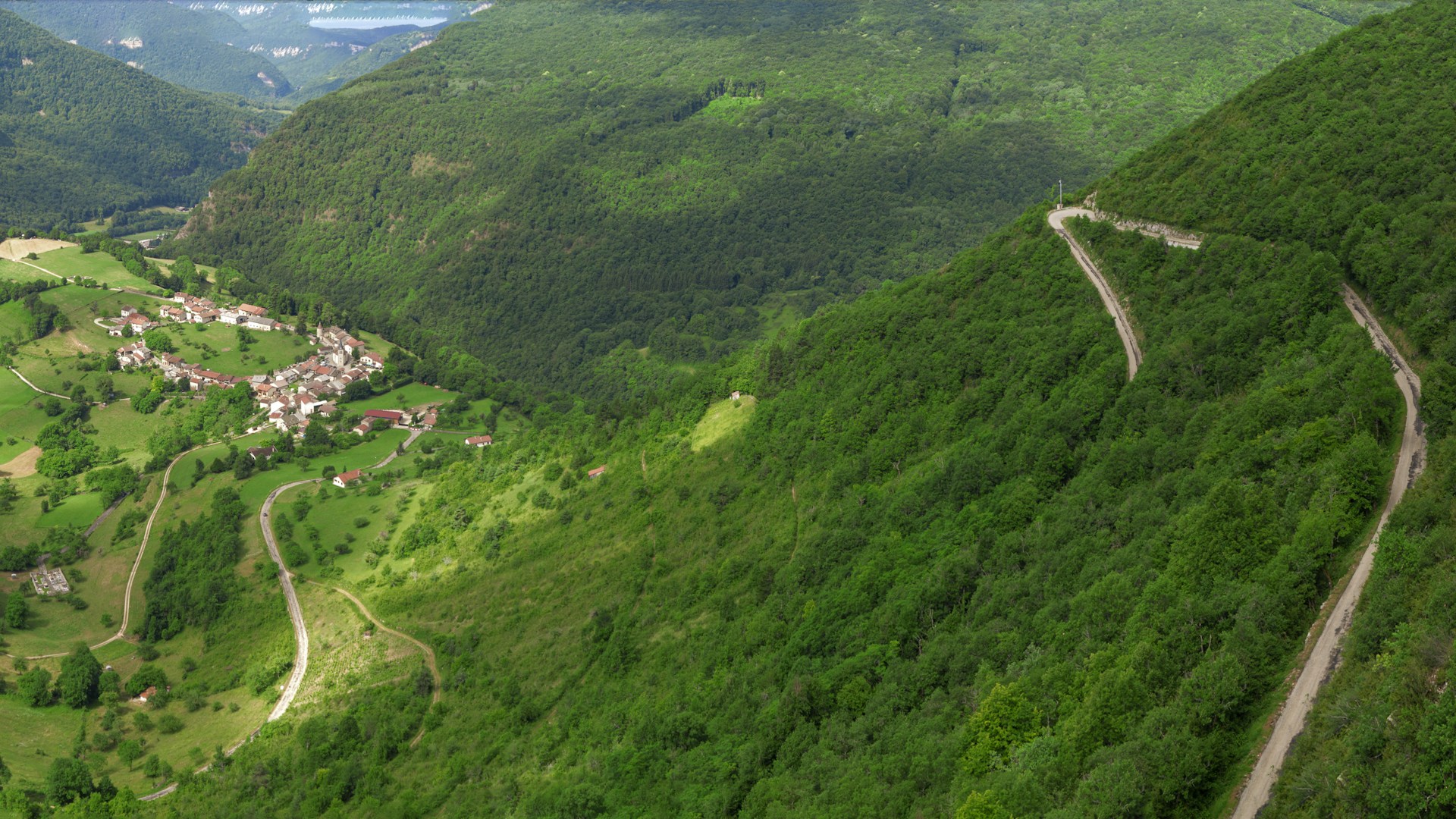 an aerial view of a winding road in the mountains