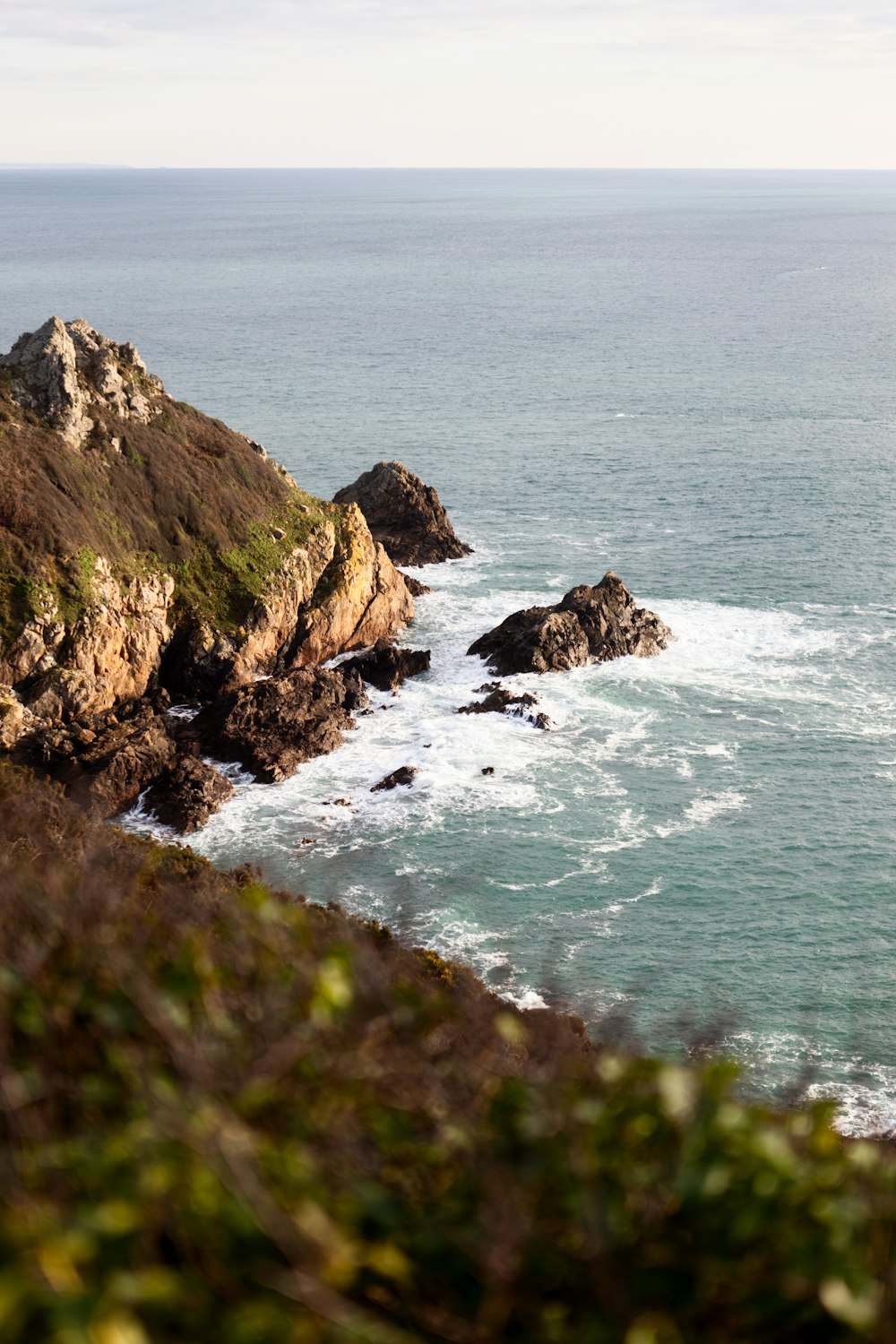 a large body of water sitting next to a lush green hillside