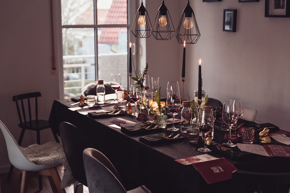 a dining room table is set with wine glasses and place settings
