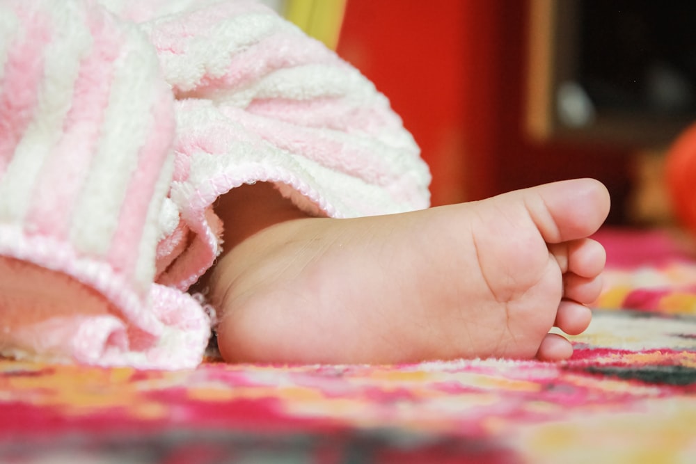 a close up of a baby's foot on a blanket