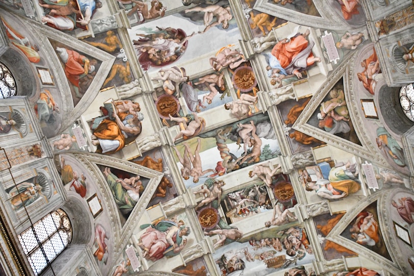 the ceiling of a building with many paintings on it
