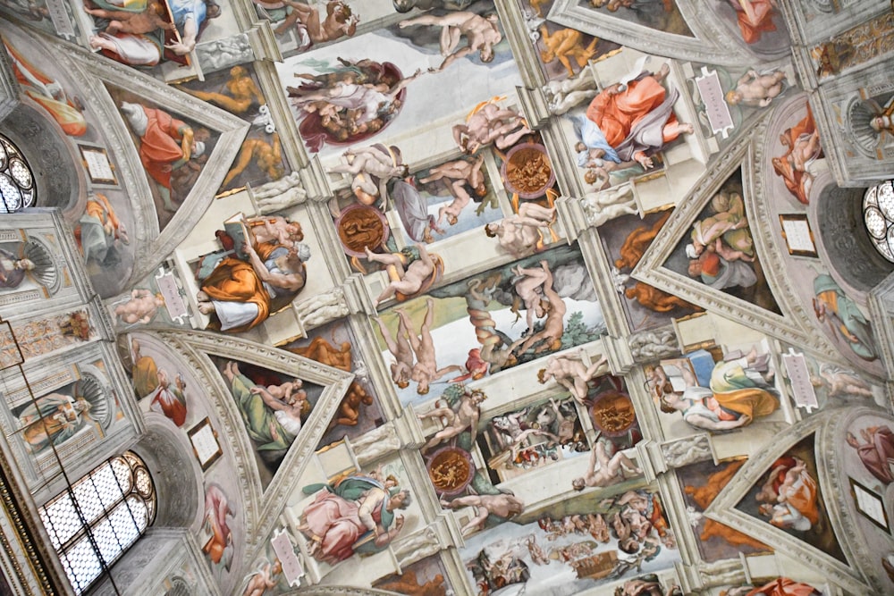 the ceiling of a building with many paintings on it