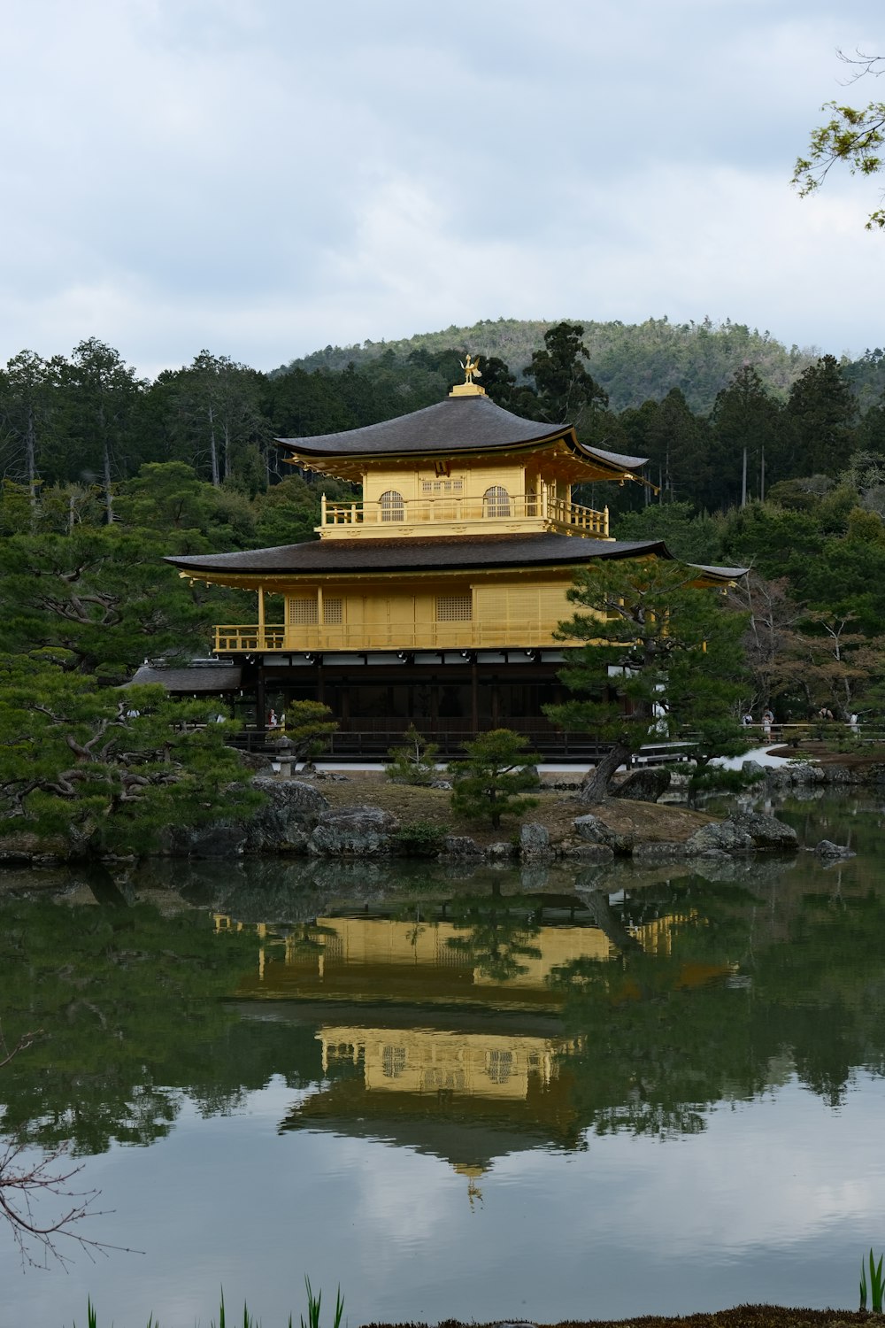 a building sitting on top of a lake next to a forest