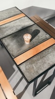 Artistic capture of a café latte with intricate foam art, set on a sleek white table.