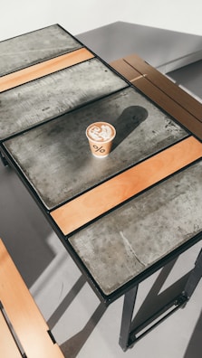 Barista carefully pouring latte art into a warm cup surrounded by minimalist décor.
