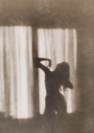 A sensual woman posing gracefully in soft evening light, evoking mystery and allure.