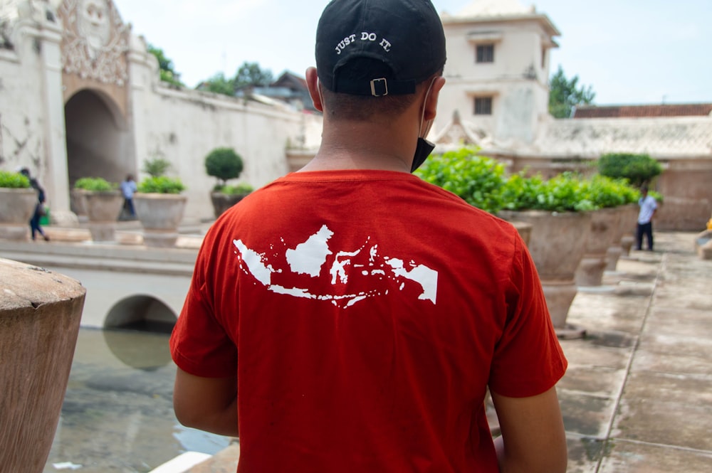 a man wearing a red shirt and a black hat