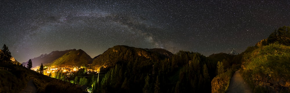a night view of a mountain range with the milky in the background