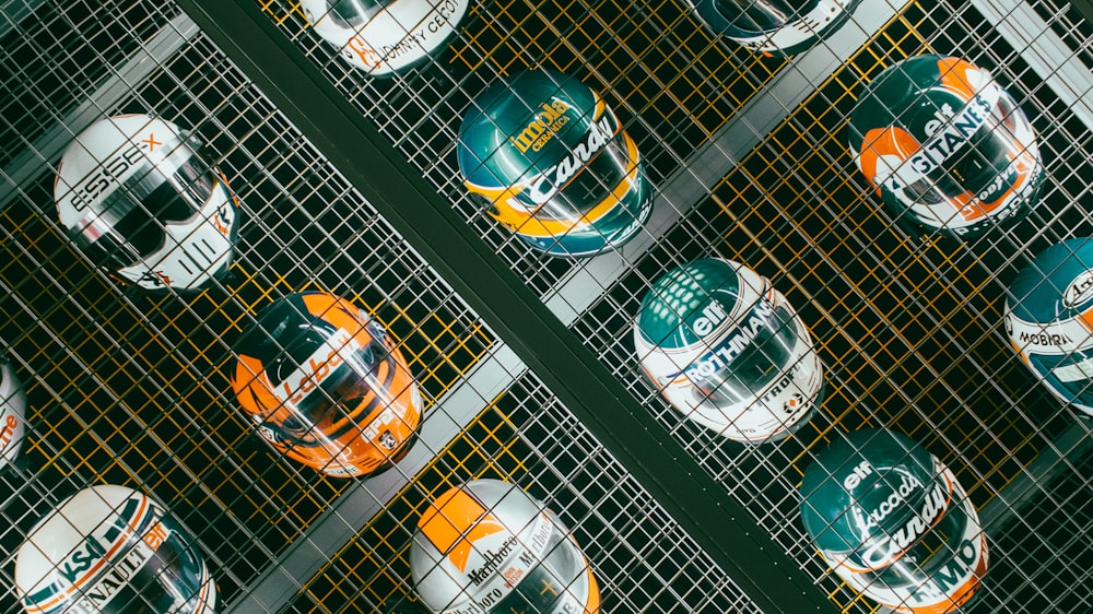 Un grupo de cascos de diferentes colores en una rejilla de metal
