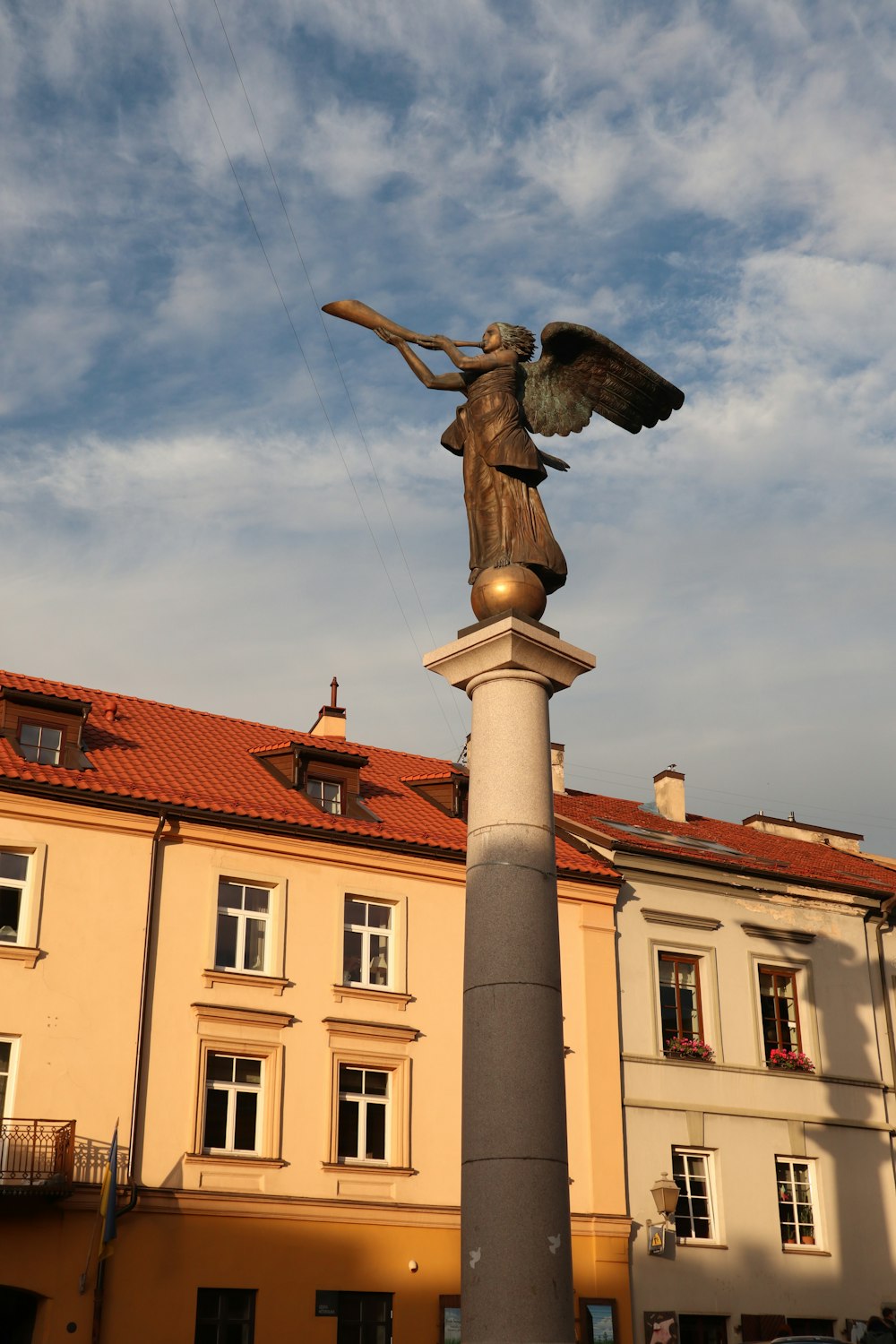 uma estátua de um anjo em cima de um poste