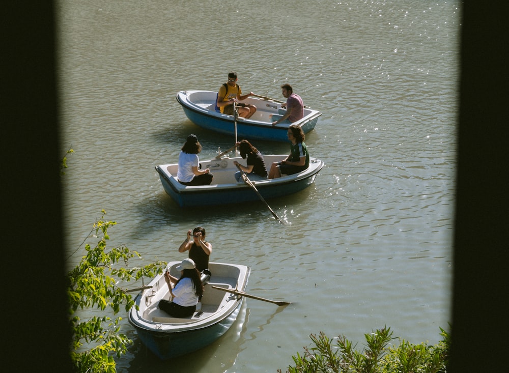 Un grupo de personas montadas en la parte superior de pequeñas embarcaciones