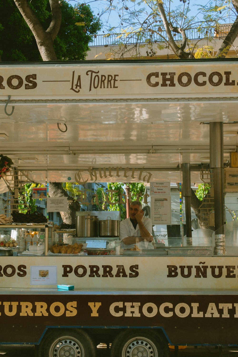 a man is behind a food cart selling chocolates