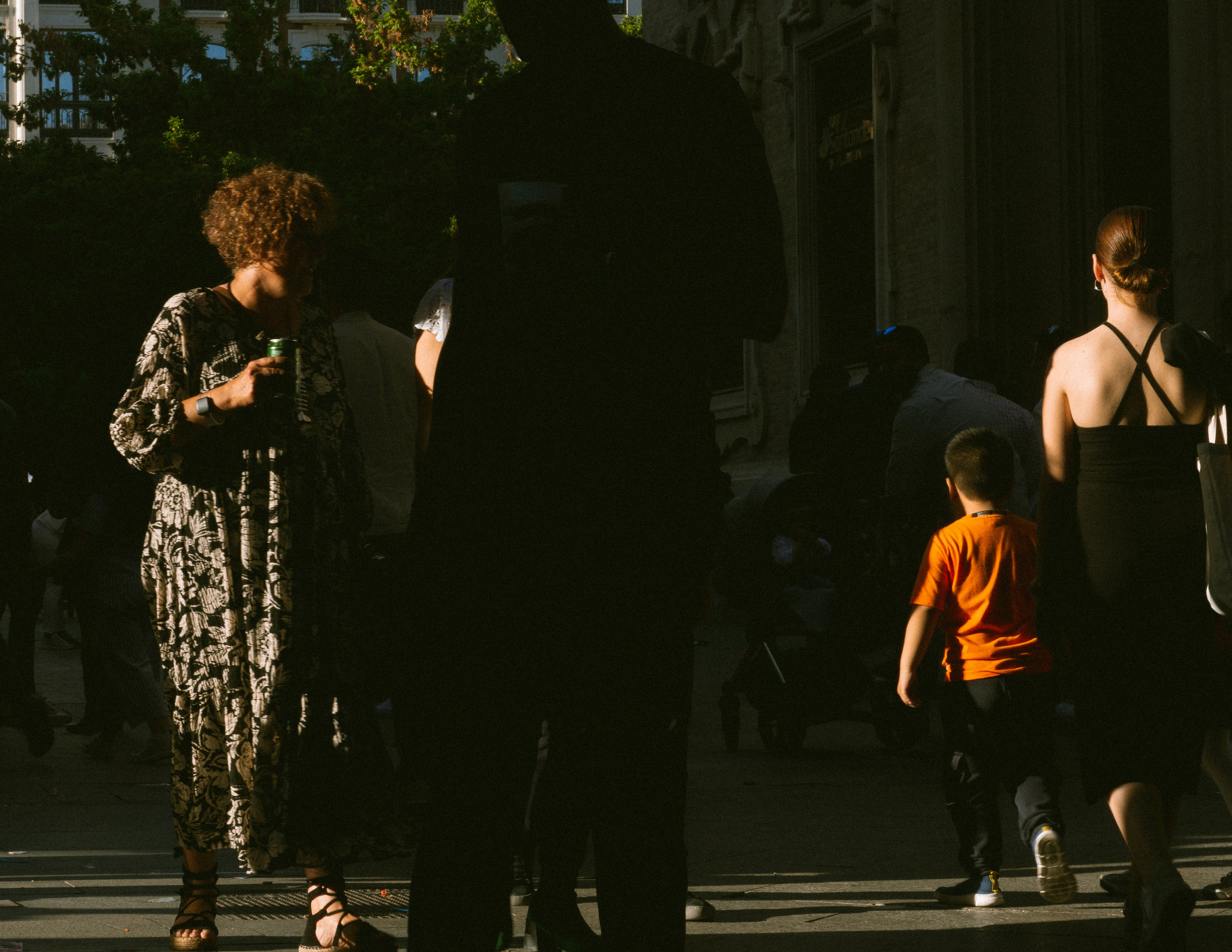 Eine Gruppe von Menschen, die eine Straße neben hohen Gebäuden entlang gehen