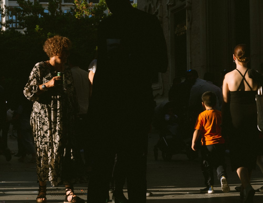 a group of people walking down a street next to tall buildings