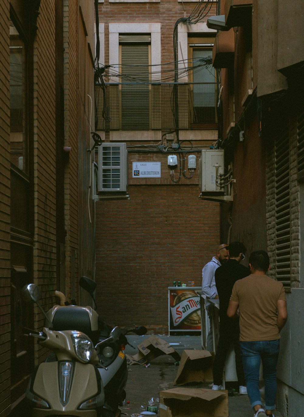 a couple of people walking down a narrow alley way