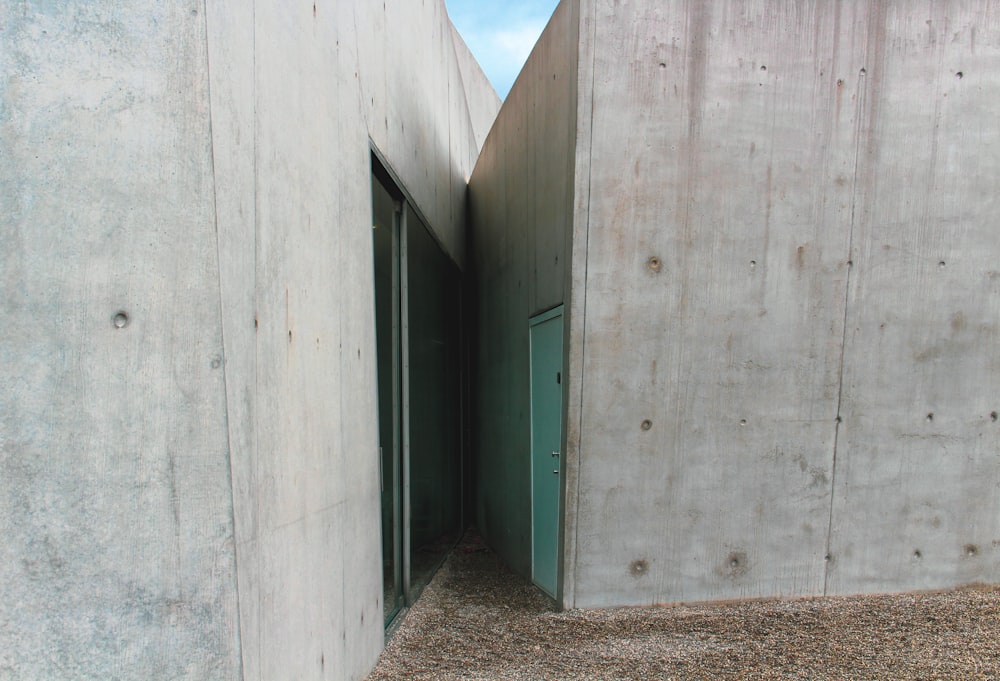 a concrete building with a green door