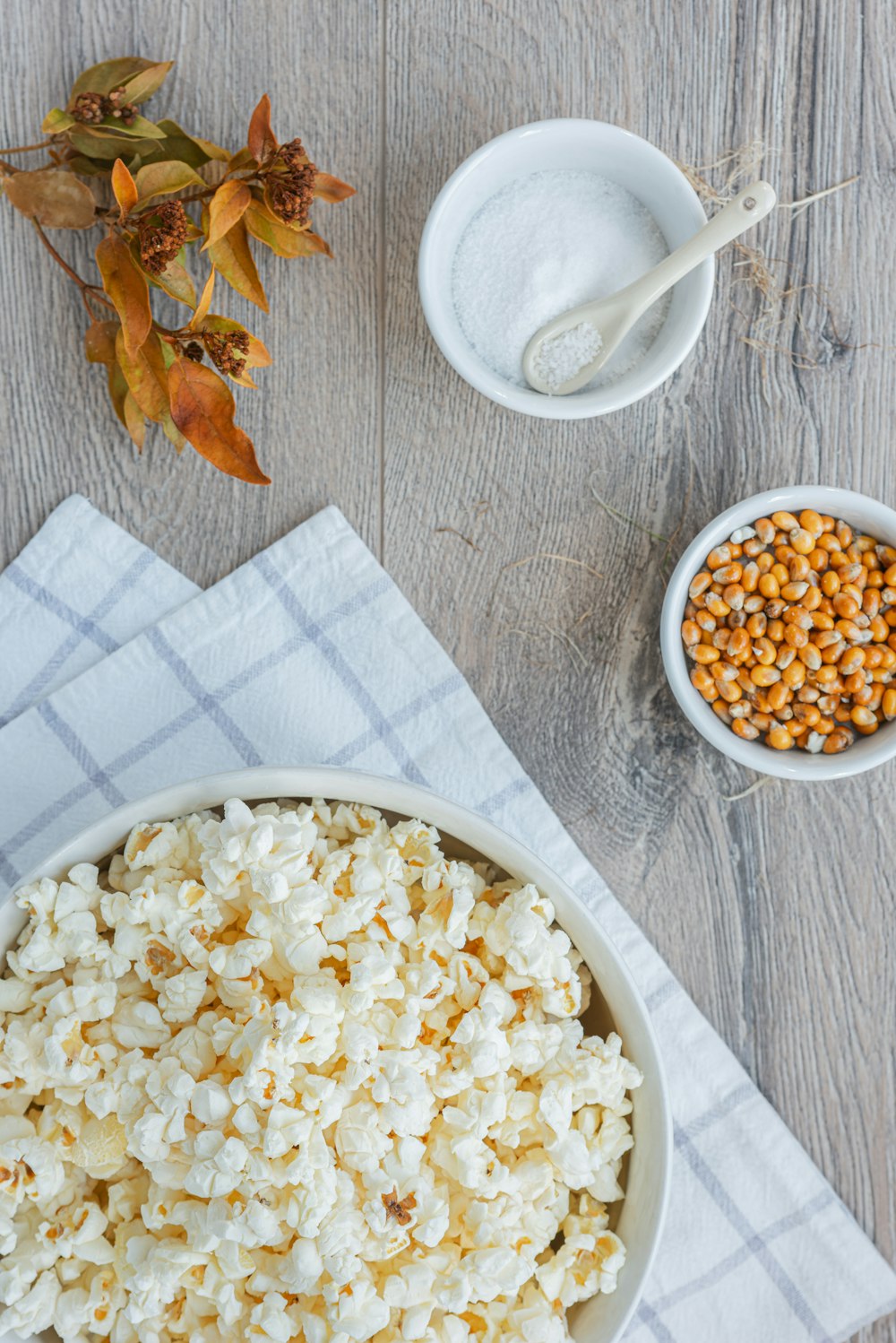 a bowl of popcorn next to a bowl of corn