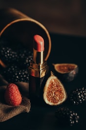 a lipstick and some fruit on a table