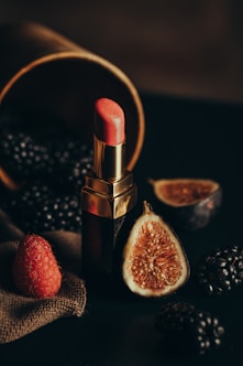 a lipstick and some fruit on a table