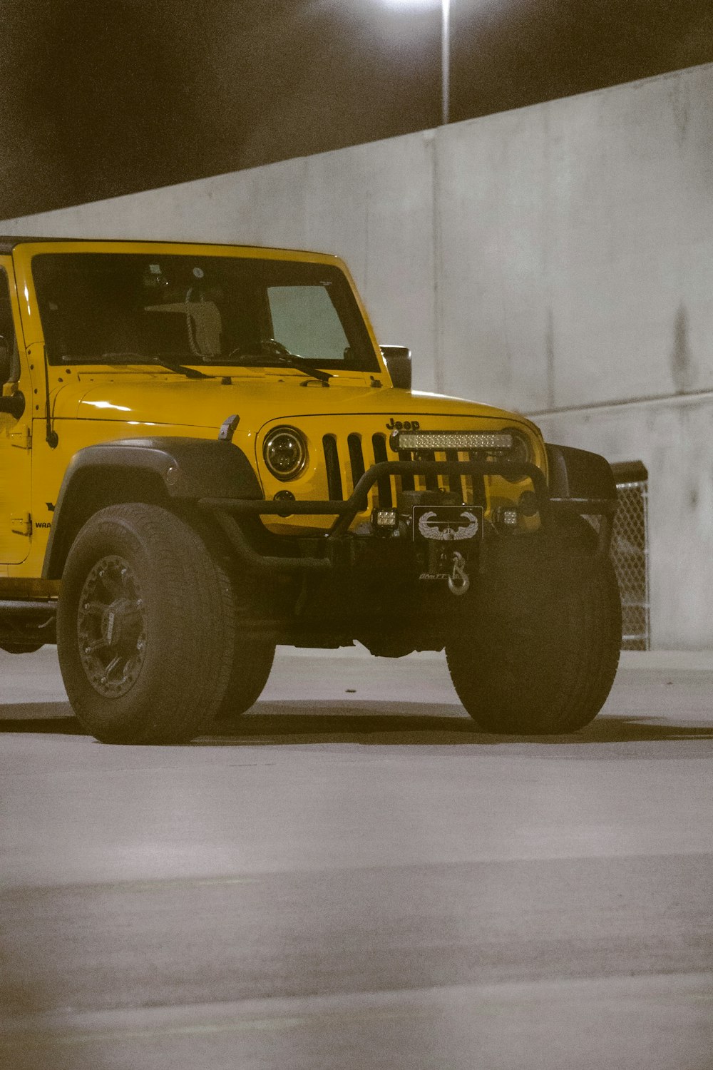 a yellow jeep parked in a parking garage