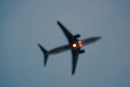 A glowing, blurred flight search card against a dark blue futuristic background.