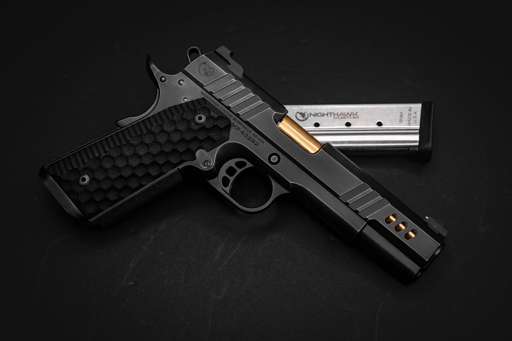 a black gun with gold accents on a black background