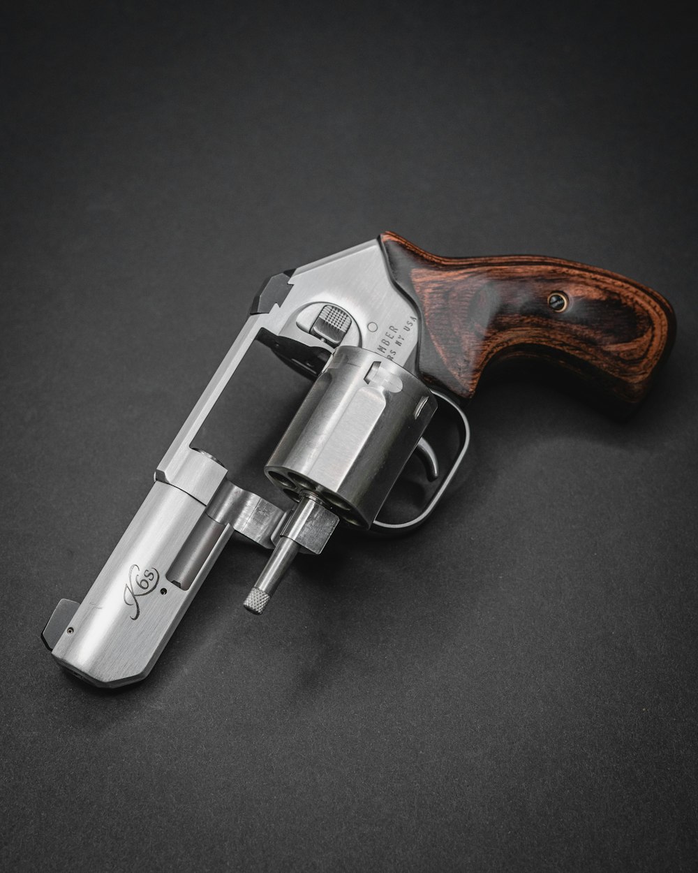 a silver revolver with a wooden handle