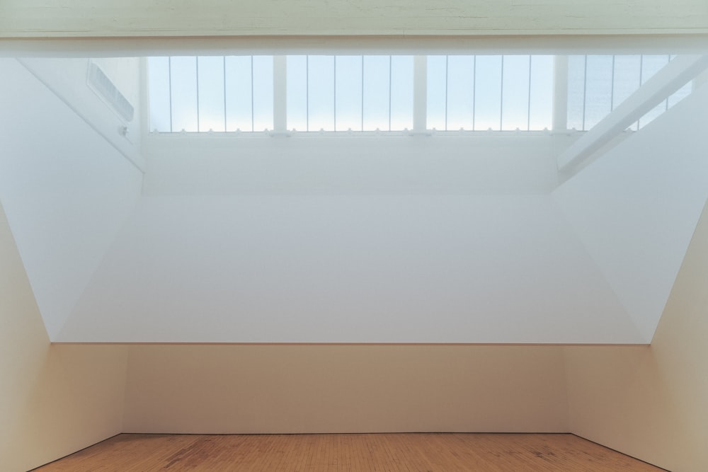 an empty room with a wooden floor and white walls