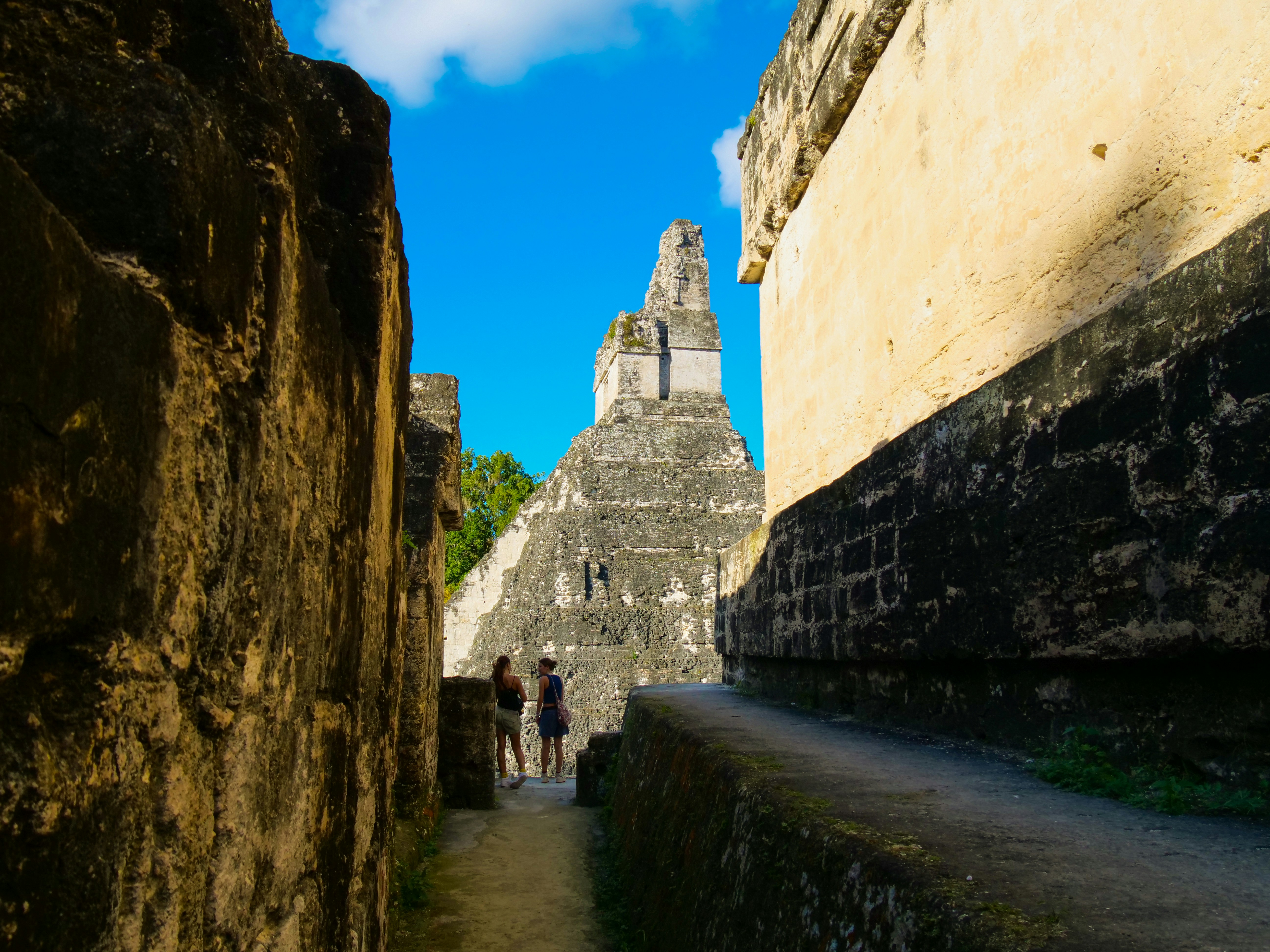 a group of people walking down a narrow street, 